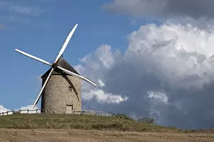 Windmill on top of a hill with a blue sky with white clouds, Normandy, France, Europe