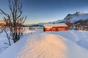 Log Cabin Gallery: The winter sun illuminates a typical Norwegian red house surrounded by fresh snow