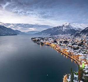 Winter sunrise over the illuminated lakeside town of Gravedona and snowy peaks, Lake Como Winter sunrise over the illuminated lakeside town of Gravedona and snowy peaks, Lake Como