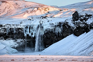 Winter view of Seljalandsfoss Waterfall bathed in evening light, South Iceland, Polar Winter view of Seljalandsfoss Waterfall bathed in evening light, South Iceland, Polar