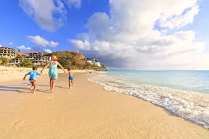 Woman and children running happily on Ffryes Beach, Antigua, Antigua and Barbuda Woman and children running happily on Ffryes Beach, Antigua, Antigua and Barbuda