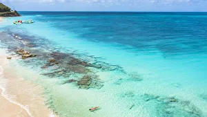 Woman floating in the crystal sea on idyllic tropical beach, overhead view, Antigua, Leeward Islands, West Indies Woman floating in the crystal sea on idyllic tropical beach, overhead view, Antigua, Leeward Islands, West Indies