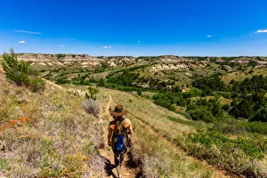 Woman hiking along The Petrified Forest Loop Trail inside Theodore Roosevelt National Woman hiking along The Petrified Forest Loop Trail inside Theodore Roosevelt National