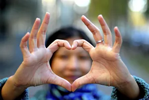 Woman making a heart with her fingers, Paris, France, Europe Woman making a heart with her fingers, Paris, France, Europe
