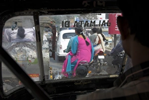 Women riding on back of motorcycles in heavy traffic Women riding on back of motorcycles in heavy traffic
