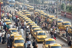 Yellow Kolkata taxis and commuters outside Howrah Railway Station in morning rush hour Yellow Kolkata taxis and commuters outside Howrah Railway Station in morning rush hour