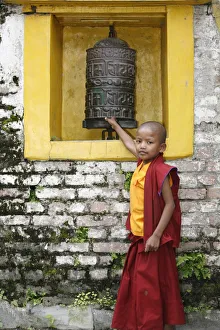 Young monk and prayer wheel, Swayambhunath temple, Kathmandu, Nepal, Asia Young monk and prayer wheel, Swayambhunath temple, Kathmandu, Nepal, Asia
