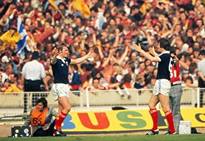 Images Dated 4th June 1977: Kenny Dalglish celebrates his goal with Bruce Rioch in front of the Scotland fans at Wembley - 1977 British Home Championship
