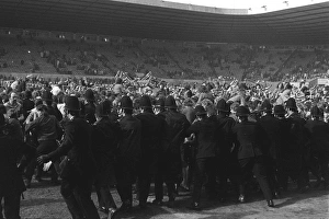 Police try to stop Manchester United fans invading the Old Trafford pitch after Denis Laws goal relegates the club in Police try to stop Manchester United fans invading the Old Trafford pitch after Denis Laws goal relegates the club in