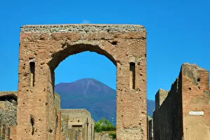 Images Dated 23rd September 2019: Ruined archway in the ancient Roman city of Pompeii and Mount Vesuvius, Italy