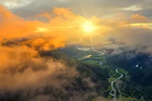 Aerial view of sun rays in the sunset sky lighting up the clouds over Romsdalen valley Aerial view of sun rays in the sunset sky lighting up the clouds over Romsdalen valley
