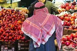 Images Dated 18th January 2014: Arab man waerinf Keffiyeh buying apples in market, Amman, Jordan