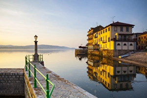 Aronas Picturesque lake-front illuminated at sunrise, Arona, Lake Maggiore, Piedmont Aronas Picturesque lake-front illuminated at sunrise, Arona, Lake Maggiore, Piedmont