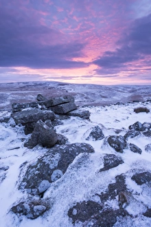 Beautiful sunrise over a frozen snow covered moorland, Belstone Tor, Dartmoor, Devon Beautiful sunrise over a frozen snow covered moorland, Belstone Tor, Dartmoor, Devon