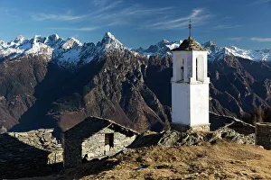 The bell tower of Alpe Scima, with Pizzo di Prata in the background, in winter The bell tower of Alpe Scima, with Pizzo di Prata in the background, in winter
