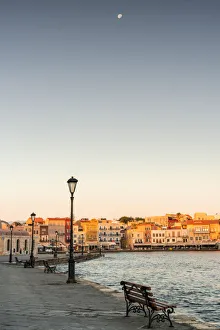Bench on waterfront in the old Venetian harbour of Chania at dawn, Crete island, Greece Bench on waterfront in the old Venetian harbour of Chania at dawn, Crete island, Greece