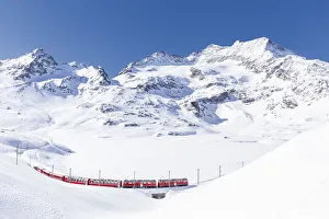 Bernina Express transit along Lago Bianco in winter, Bernina Pass, Engadin Bernina Express transit along Lago Bianco in winter, Bernina Pass, Engadin
