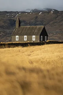 Buoakirkja Black Church on field against mountain in Budir, Snaefellsness Peninsula Buoakirkja Black Church on field against mountain in Budir, Snaefellsness Peninsula