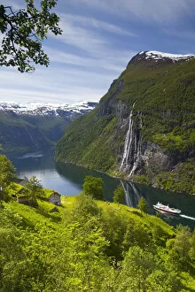 Car Ferry Collection: A car ferry passes beneath an old abandoned farm & the Seven Sisters waterfall, Geiranger