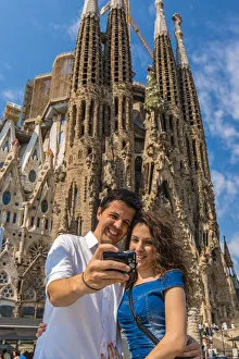 Caucasian young couple taking photo of themselves in front of Sagrada Familia church Caucasian young couple taking photo of themselves in front of Sagrada Familia church