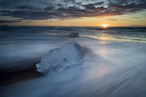 Sudurland Region Gallery: Chunk of ice on shore at Diamond beach near Jokulsarlon glacier lagoon during sunrise