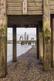 City of London skyline through a wooden bridge on the River Thames, London, England City of London skyline through a wooden bridge on the River Thames, London, England