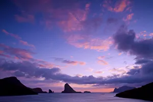 A colorful sunset seen from the village of Sorvagur (island of Vagar). In the background Drangarnir seastacks A colorful sunset seen from the village of Sorvagur (island of Vagar). In the background Drangarnir seastacks