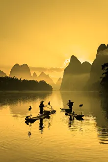 Cormorant fisherman throwing net on Li River at dawn, Xingping, Yangshuo, Guangxi, China Cormorant fisherman throwing net on Li River at dawn, Xingping, Yangshuo, Guangxi, China