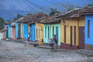 Cuba, Trinidad, A man selling sandwiches blows a whistle as he walkes up a Colourful Cuba, Trinidad, A man selling sandwiches blows a whistle as he walkes up a Colourful
