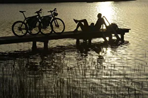 Electric cyclists on jetty, Klostersee Castle Seeon, Chiemgau, Upper Bavaria, Bavaria Electric cyclists on jetty, Klostersee Castle Seeon, Chiemgau, Upper Bavaria, Bavaria