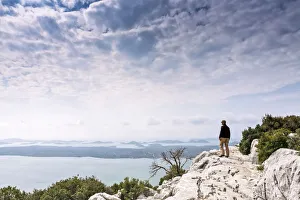 Europe, Croatia, Dalmatia, Zadar county, Kamenjak viewpoint, a hiker looking out over Europe, Croatia, Dalmatia, Zadar county, Kamenjak viewpoint, a hiker looking out over