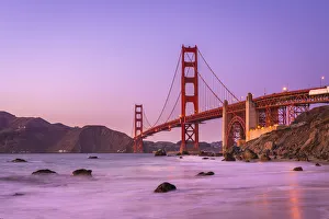 Famous Golden Gate Bridge over bay against purple sky during sunset, San Francisco Famous Golden Gate Bridge over bay against purple sky during sunset, San Francisco