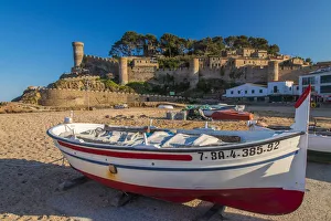 Fishing boat on the beach with medieval town walls in the background, Tossa del Mar Fishing boat on the beach with medieval town walls in the background, Tossa del Mar