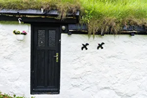 Flowerpot and ornaments on facade of iconic house with grass roof, Mykines island Flowerpot and ornaments on facade of iconic house with grass roof, Mykines island