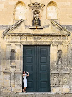 France, Provence, Arles, Notra Dame de la Major, Woman taking photograph in church France, Provence, Arles, Notra Dame de la Major, Woman taking photograph in church