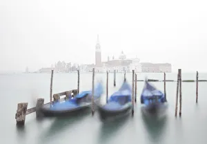 Gondolas moored at the Bacino di San Marco with a slightly visible Church of San Giorgio Gondolas moored at the Bacino di San Marco with a slightly visible Church of San Giorgio
