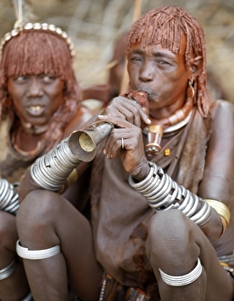 A Hamar woman blows a tin trumpet at a Jumping A Hamar woman blows a tin trumpet at a Jumping
