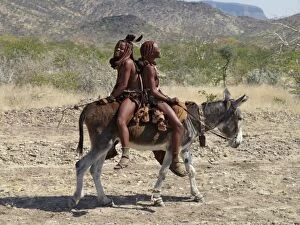 Images Dated 14th June 2006: Two happy Himba girls ride a donkey to market