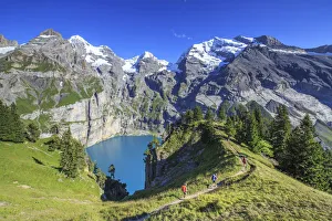 Hikers around Lake Oeschinensee Bernese Oberland Kandersteg Canton of Bern Switzerland Hikers around Lake Oeschinensee Bernese Oberland Kandersteg Canton of Bern Switzerland