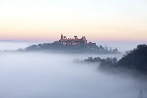 Hilltop village of Turenne surrounded by mist, Correze; Nouvelle-Aquitaine; France Hilltop village of Turenne surrounded by mist, Correze; Nouvelle-Aquitaine; France