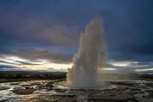 Sudurland Region Gallery: Hot spring splashing at Strokkur against cloudy sky during sunset, Geysir, South Iceland