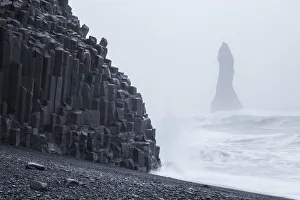 Iceland, Basalt columns on the Viks beach and cliffs wrapped in mist Iceland, Basalt columns on the Viks beach and cliffs wrapped in mist