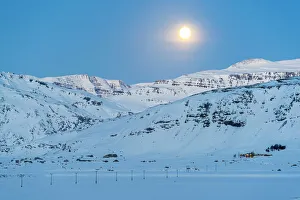 Iceland, Europe. Lonely house on the mountains in a winter landscape with full moon Iceland, Europe. Lonely house on the mountains in a winter landscape with full moon