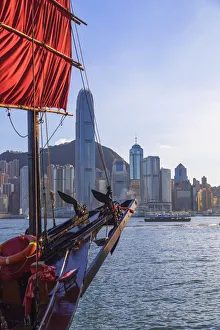 Junk boat and skyline of Hong Kong Island, Hong Kong Junk boat and skyline of Hong Kong Island, Hong Kong