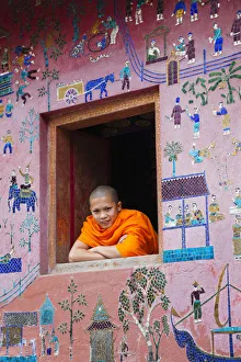 Laos, Luang Prabang, Wat Xieng Thong, Monk at Window of the Reclining Buddha Sanctuary Laos, Luang Prabang, Wat Xieng Thong, Monk at Window of the Reclining Buddha Sanctuary