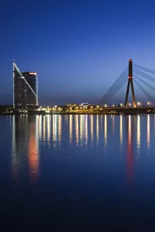 Latvia, Riga, Vansu Bridge, Swedbank building, and Daugava River, evening