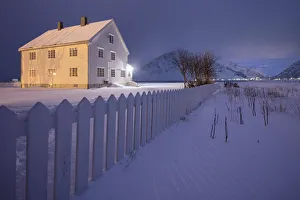 Lights on the typical wooden house surrounded by snow Flakstad Lofoten Islands Northern Lights on the typical wooden house surrounded by snow Flakstad Lofoten Islands Northern