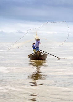 River Estuary Gallery: Local fisherman casting the fishing net from the boat, near Hoi An, Vietnam