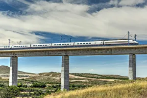 The Madrid-Barcelona AVE high-speed passenger train while is crossing a viaduct, Fuentes The Madrid-Barcelona AVE high-speed passenger train while is crossing a viaduct, Fuentes
