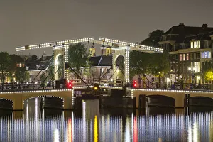 Magere Brug over the river Amstel illuminated at night, Amsterdam, North Holland Magere Brug over the river Amstel illuminated at night, Amsterdam, North Holland